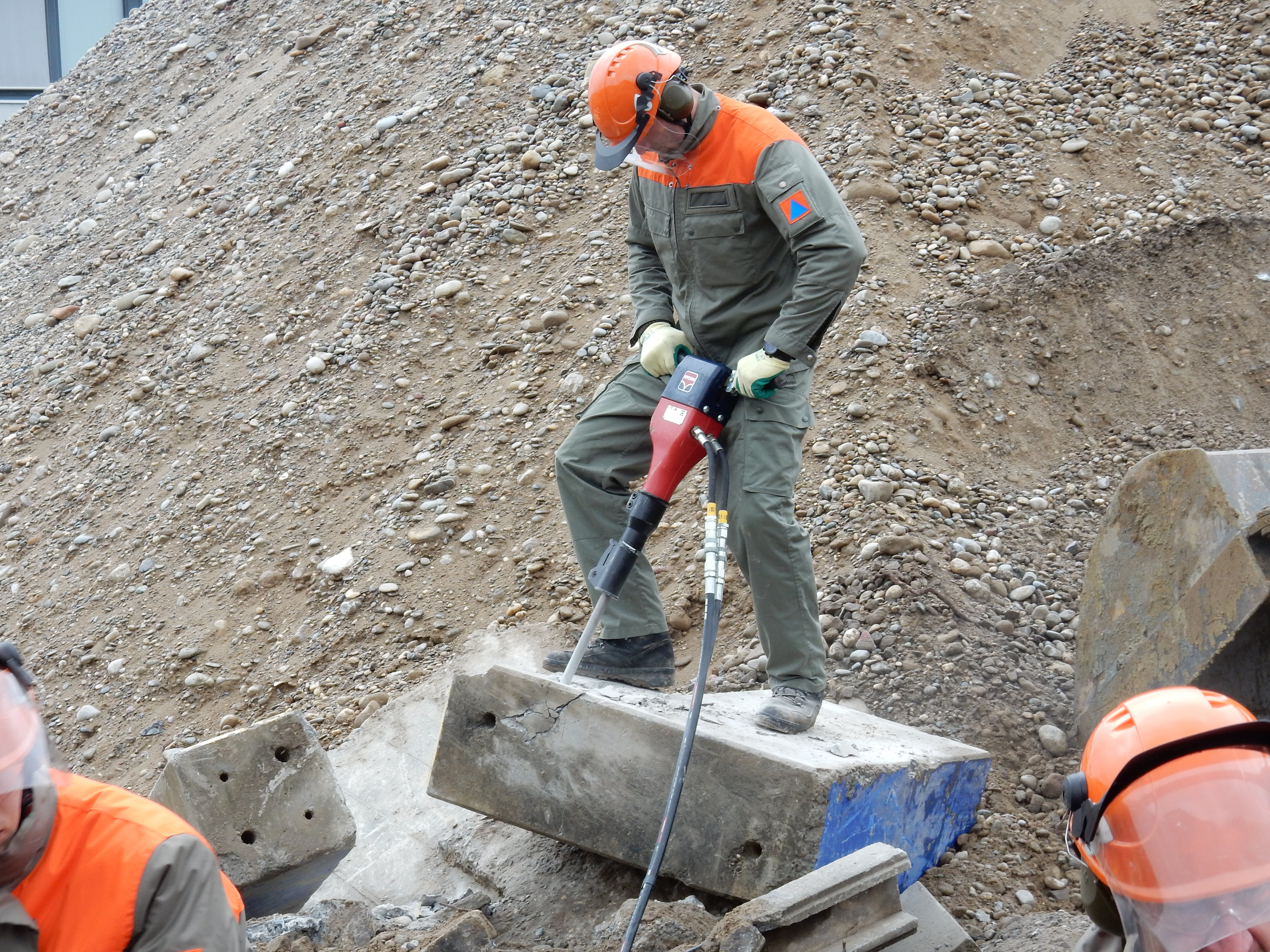 Pionier Üben mit dem Abbauhammer, um die richtige Handhabung und den sicheren Einsatz dieses Geräts zu erlernen.